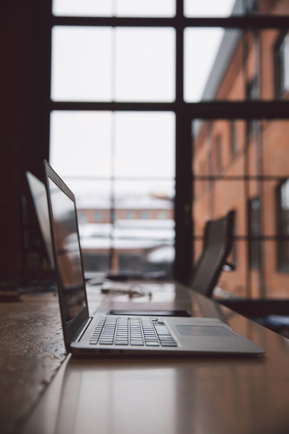 A laptop on a wooden desk in a warm, light-filled workspace — the kind of place Edmonton software and AI teams build.
