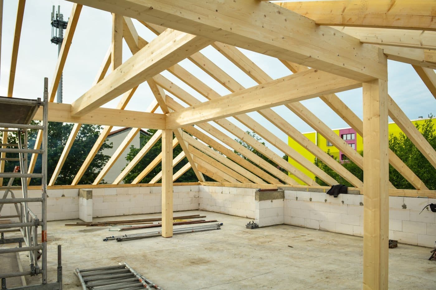 Exposed timber roof trusses on a residential construction site.